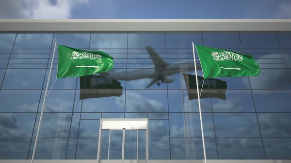 Aeroplane reflected behind Saudi flags