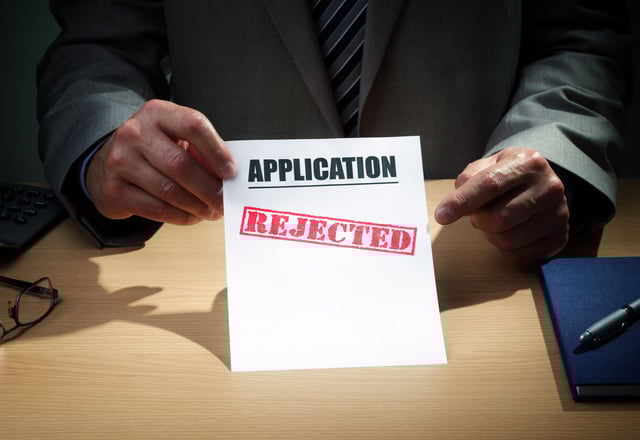 Person holding rejected application paper